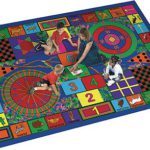A woman and two kids siting on a large play rug with many games.