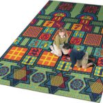 two kids playing on a large rug with hopscotch, checkers, tic-tac-toe, chinese checkers, and chess boards.