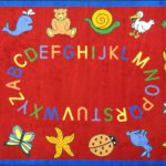A red rectangle kids rug with animals and alphabet around the edge.