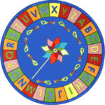 A round educational kids rug with a pinwheel in the center and the alphabet around the edge.