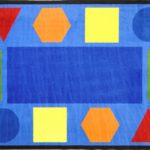 A classroom seating rug with fun shapes in different colors around the edge of the rug.
