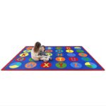 A teacher and child sitting on a fun educational kids rug with alphabet inside dots.