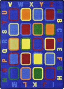 An educational rug with multi-colored squares and alphabet around the edge.